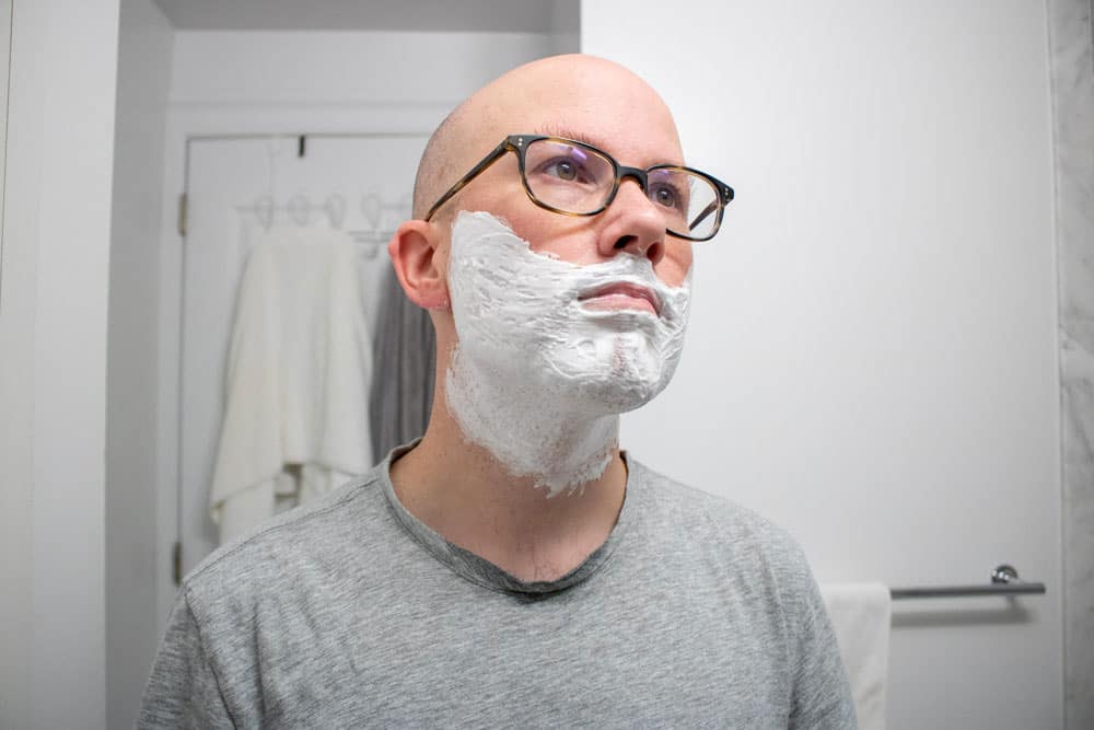 man looking upwards with cella shave cream coating his face