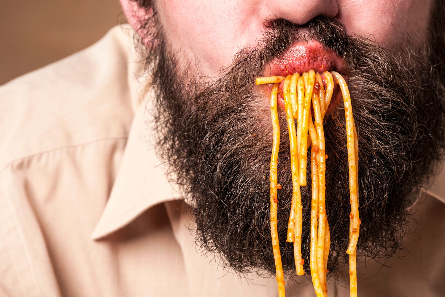 man with beard eating pasta