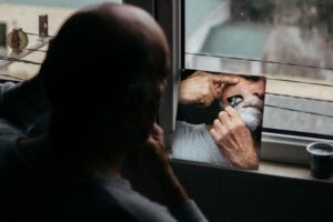 man shaving in a small mirror