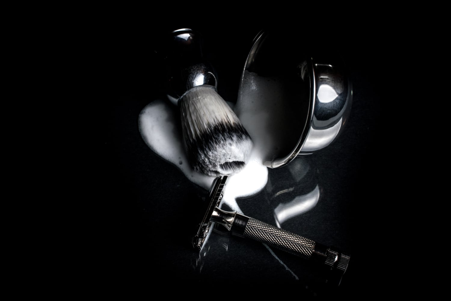 safety razor next to bowl and shaving brush