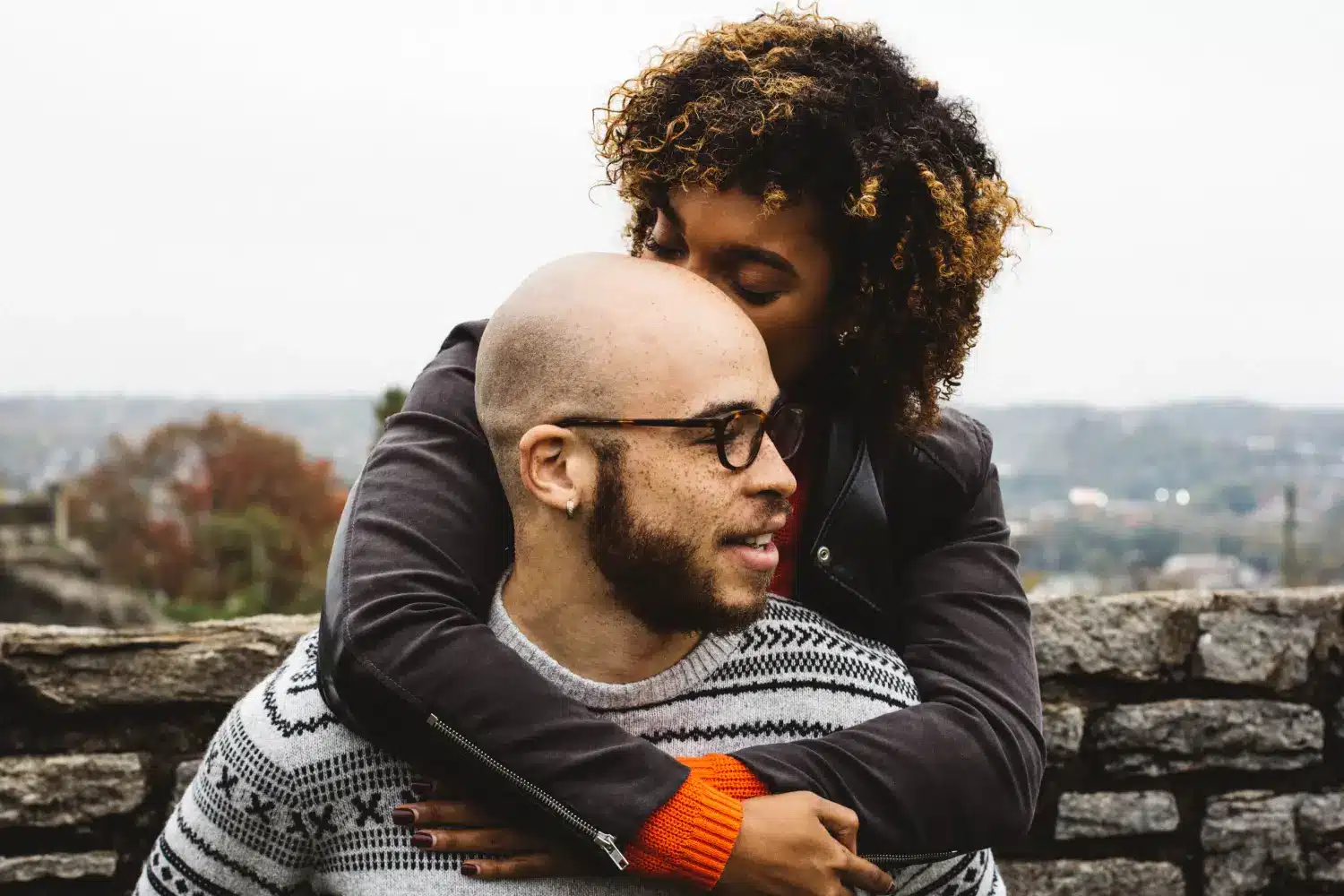 bald man being hugged by woman