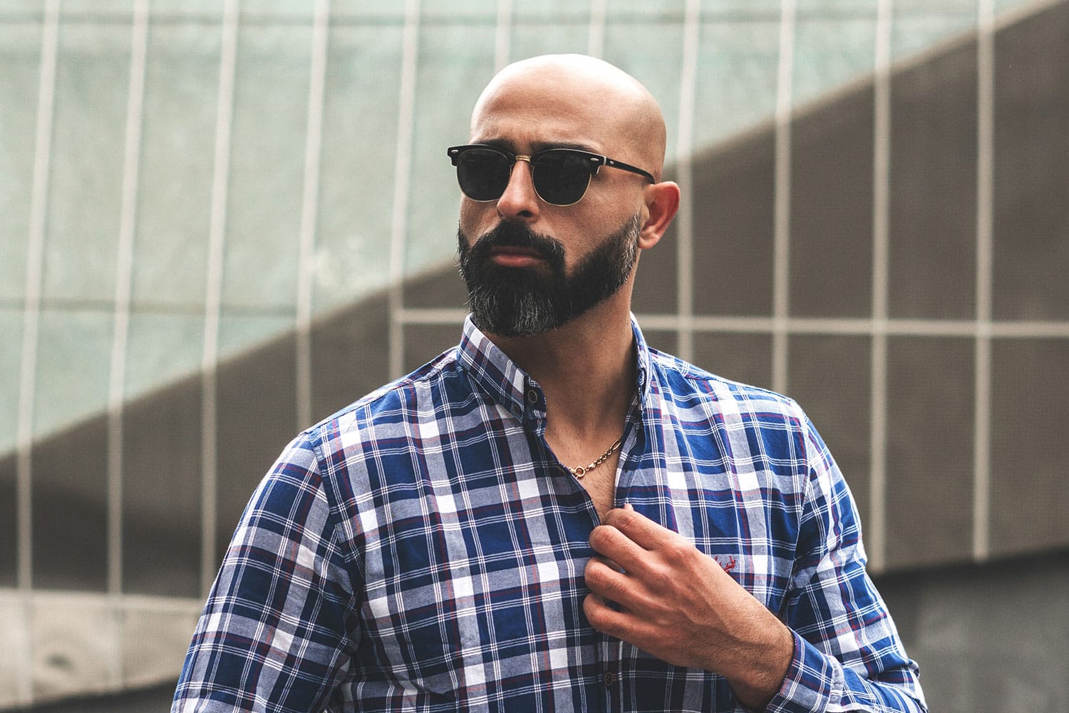 bald man wearing plaid shirt staring sideways