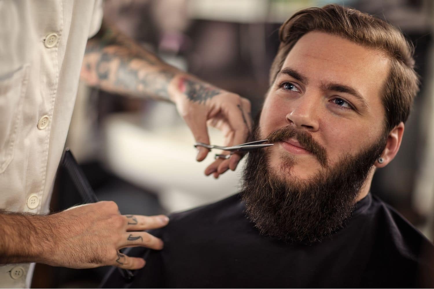 barber trimming mustache of a client