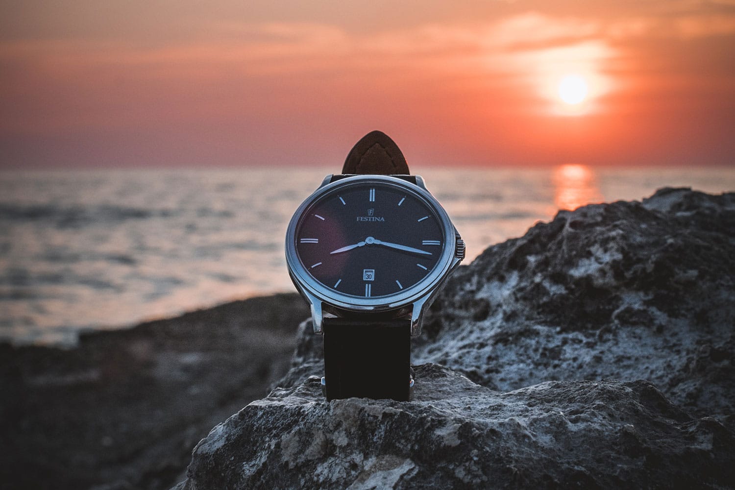 black dial watch pictured during sunset