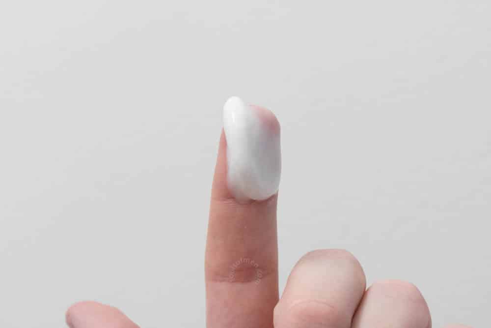 bulldog moisturizer on fingertip to demonstrate thickness