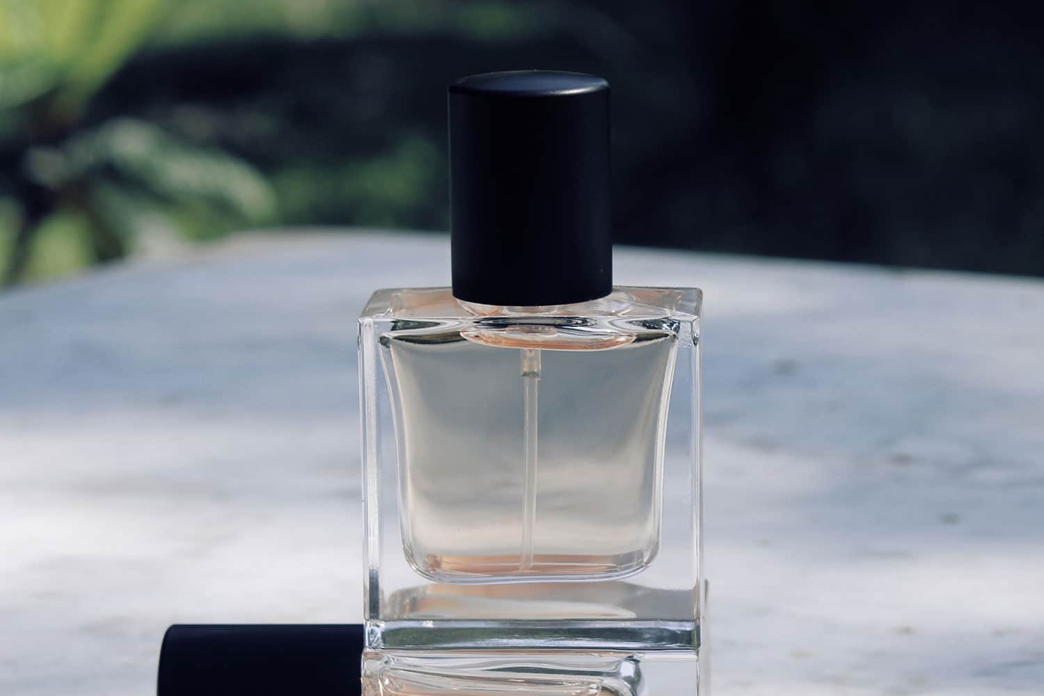 clear glass perfume bottle on a white table