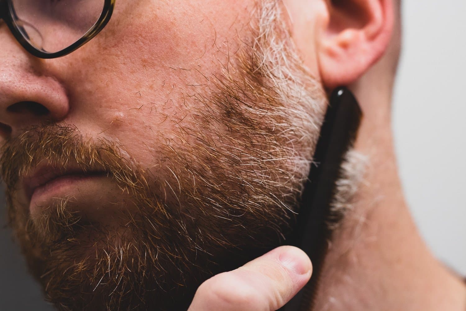 closeup of a man combing beard