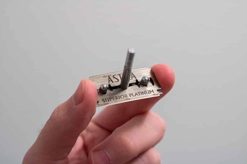 holding a razor blade that is set in the cap of a safety razor