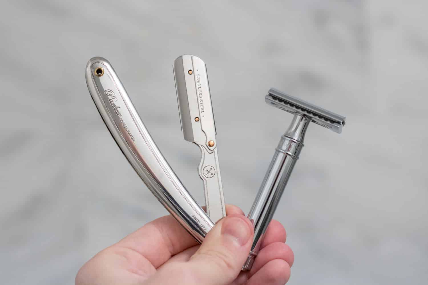 holding both a shavette and safety razor on one hand