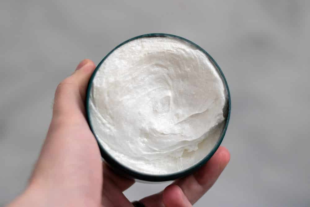 holding up body shop shaving cream to demonstrate color