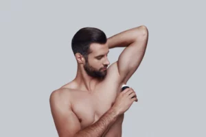 man applying deodorant
