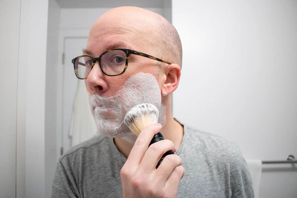 man applying ghost town barber with a shaving brush to face