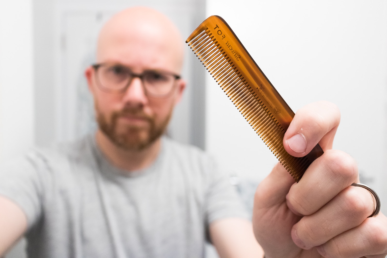 man holding a beard comb