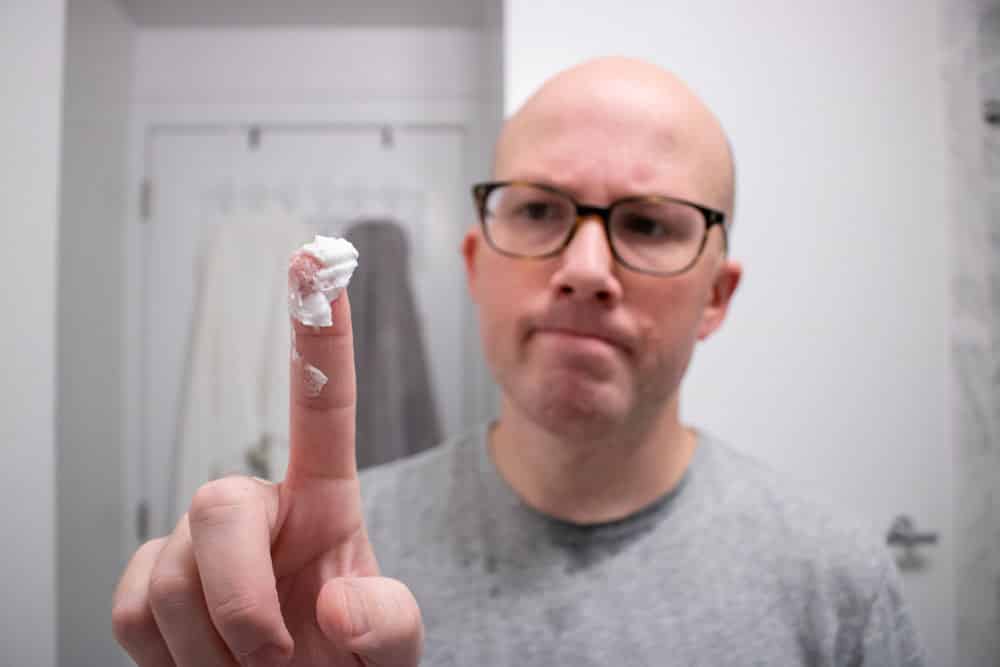 man holding proraso pre shave cream on fingertip