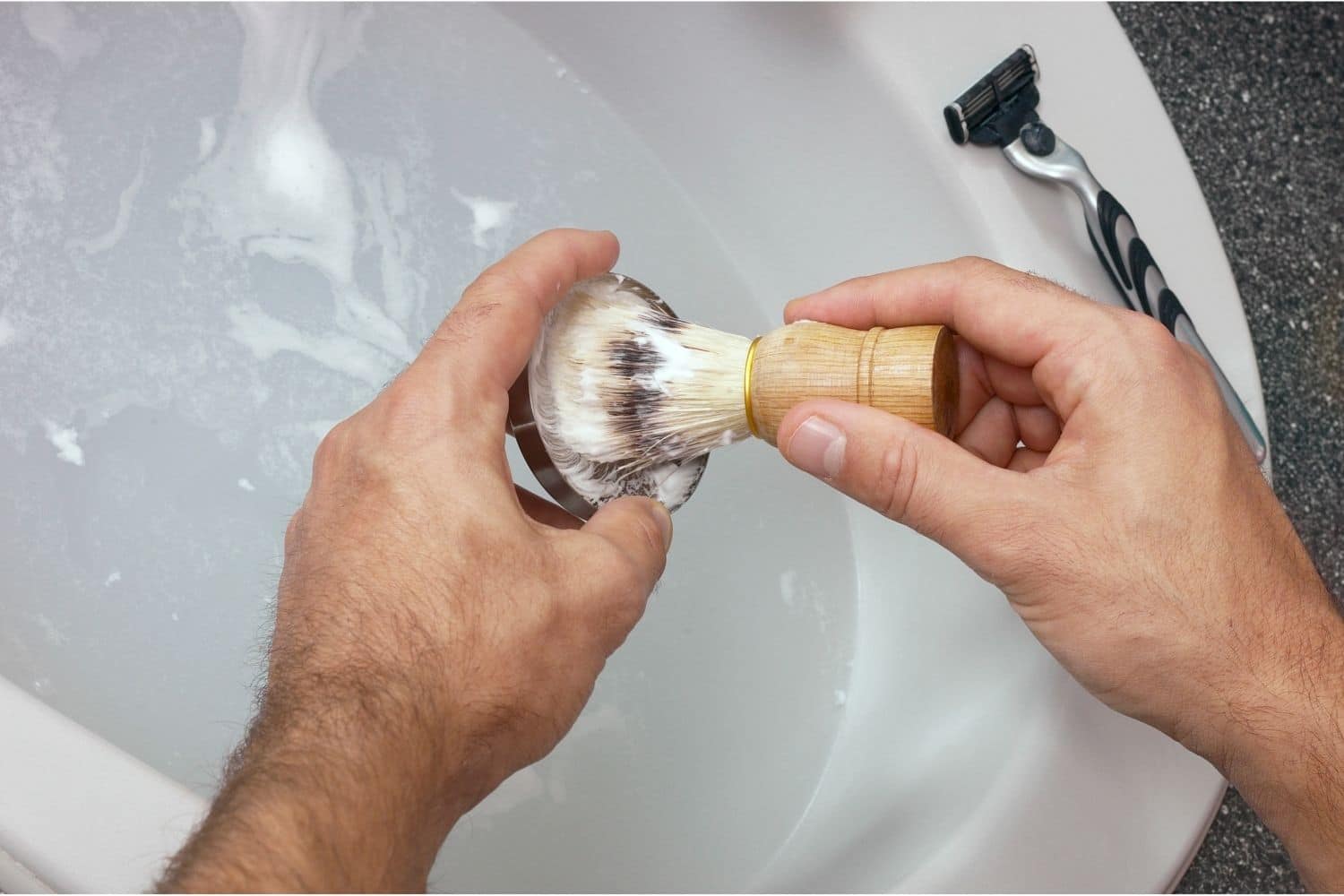 man loading a shaving brush with soap