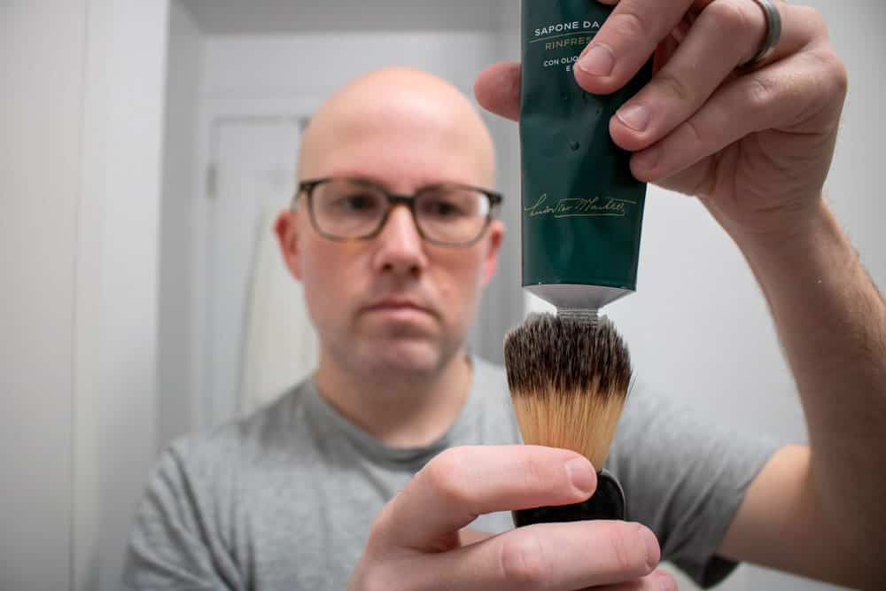 man loading shaving brush with proraso shaving cream