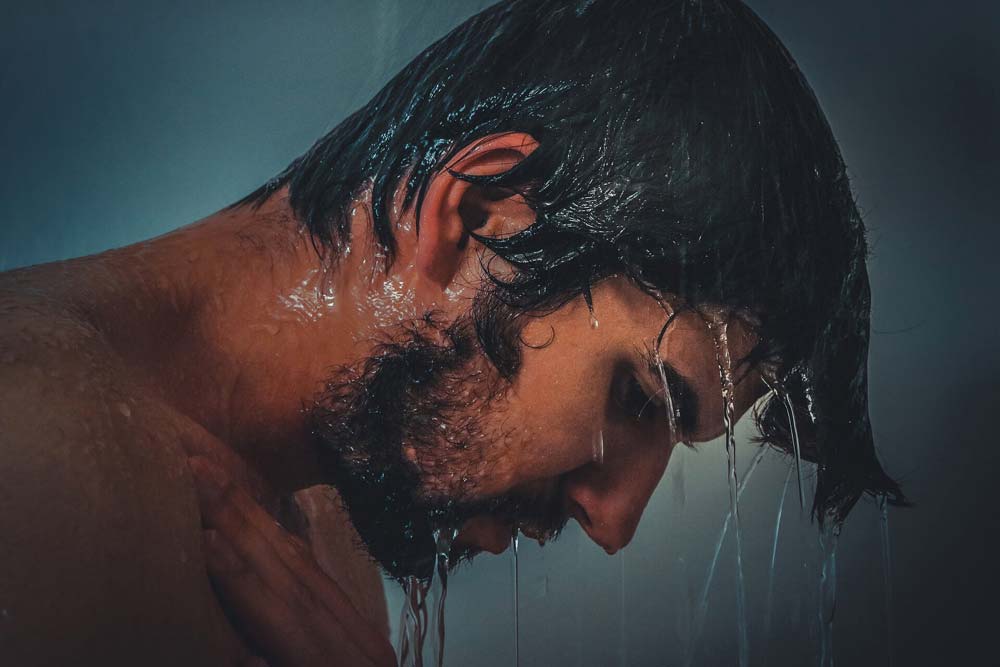 man looking down while in the shower