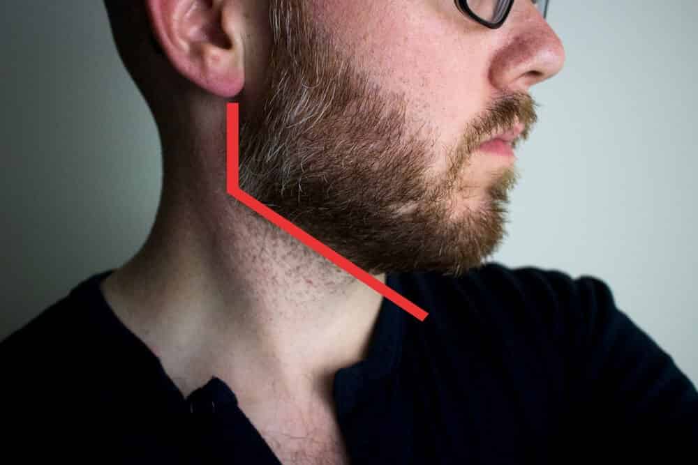 man looking to the side with red line to demonstrate proper neckline for beard