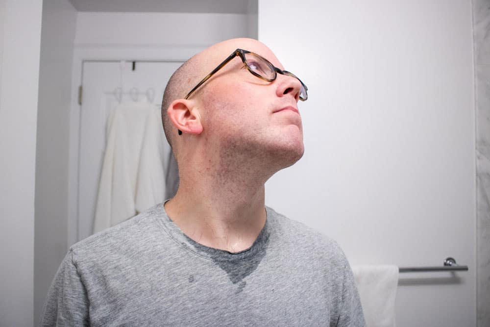 man looking up to expose neck to demonstrate quality of shave