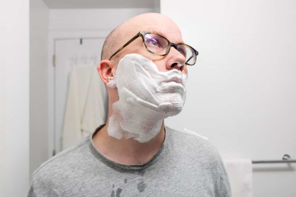 man looking up with shaving cream on face