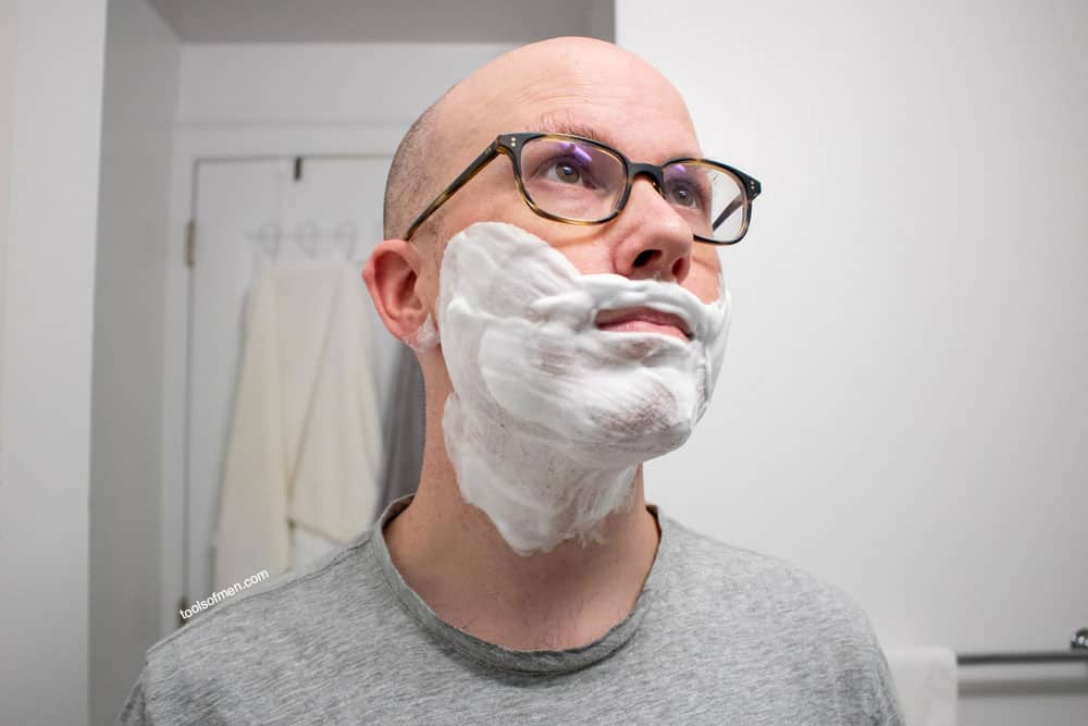 man looking up with thick shaving cream on face