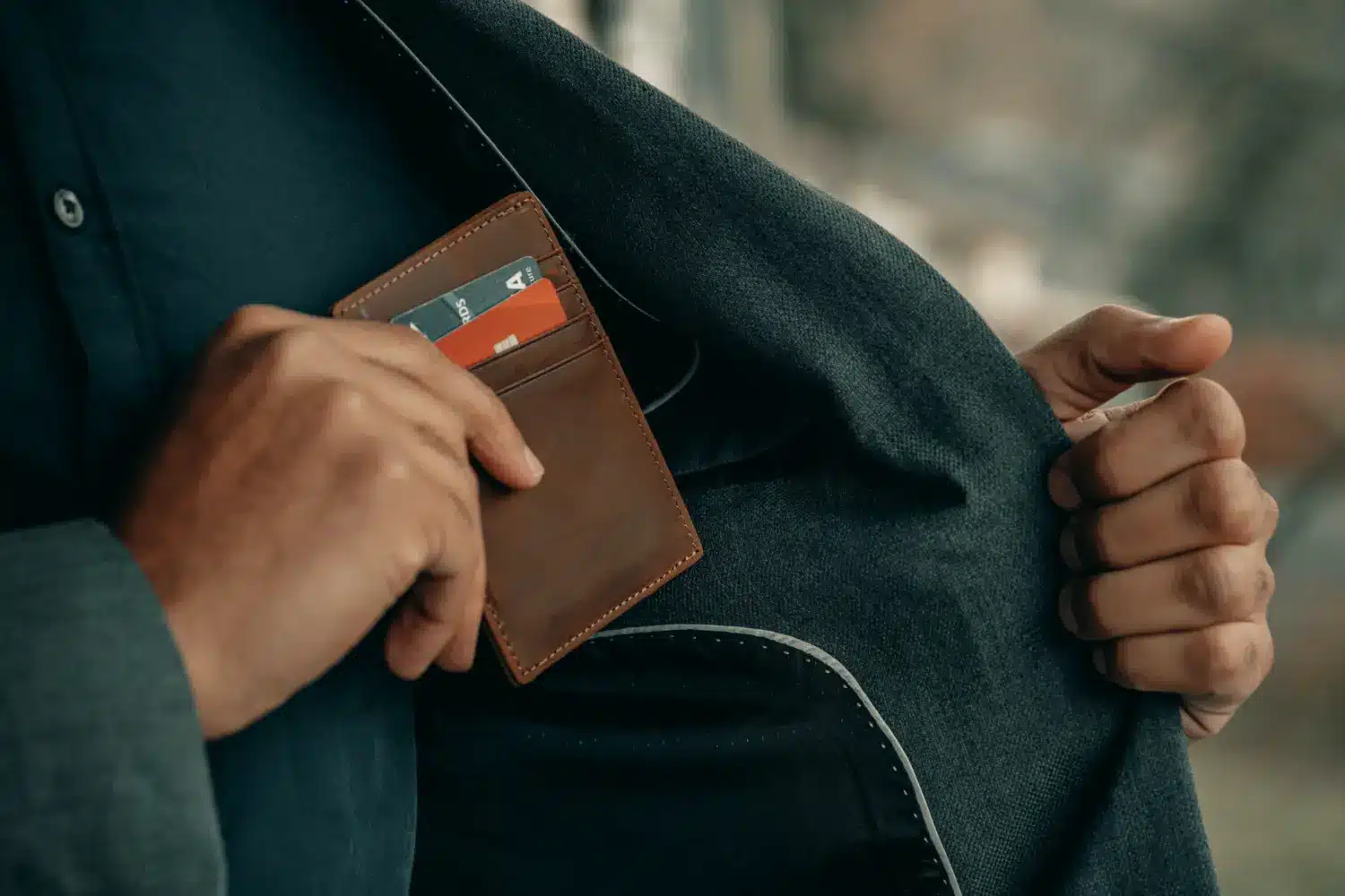 man putting wallet into suit