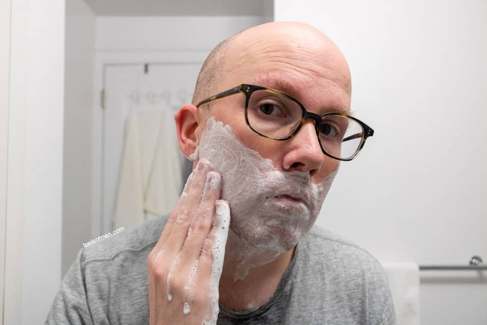 man rubbing face with shaving cream on face