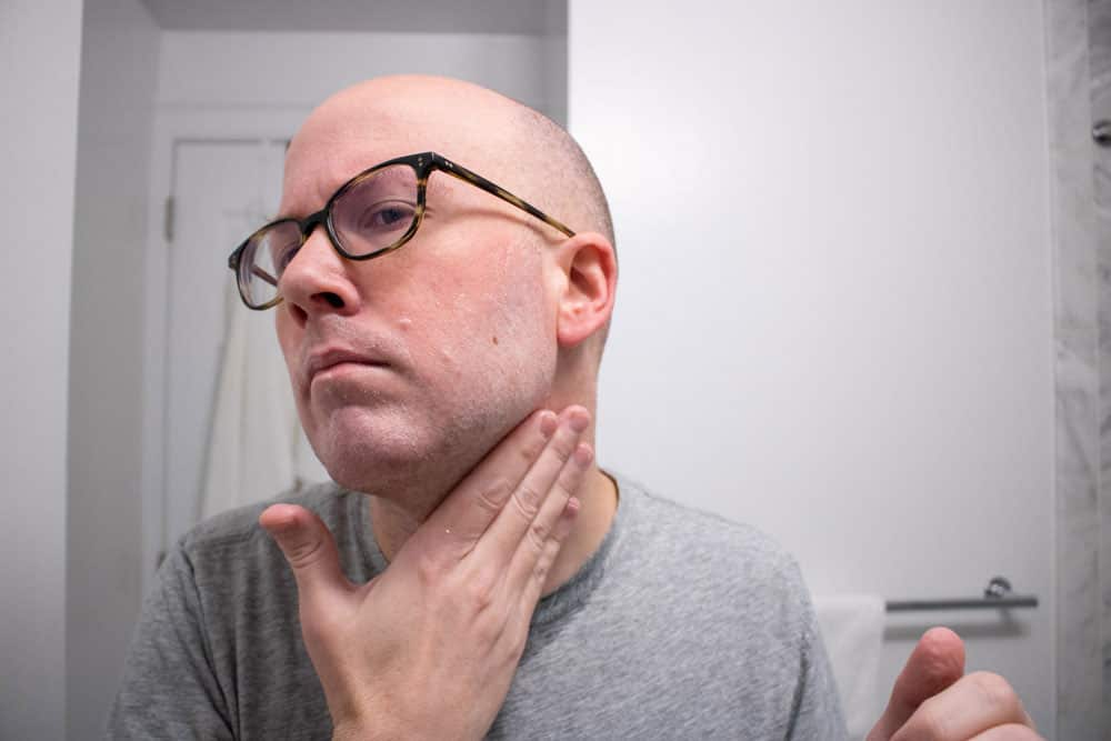 man rubbing proraso pre shave cream on face