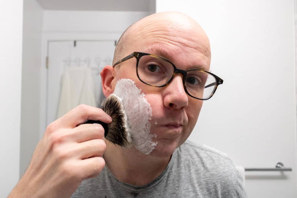 man rubbing shaving brush on face 1