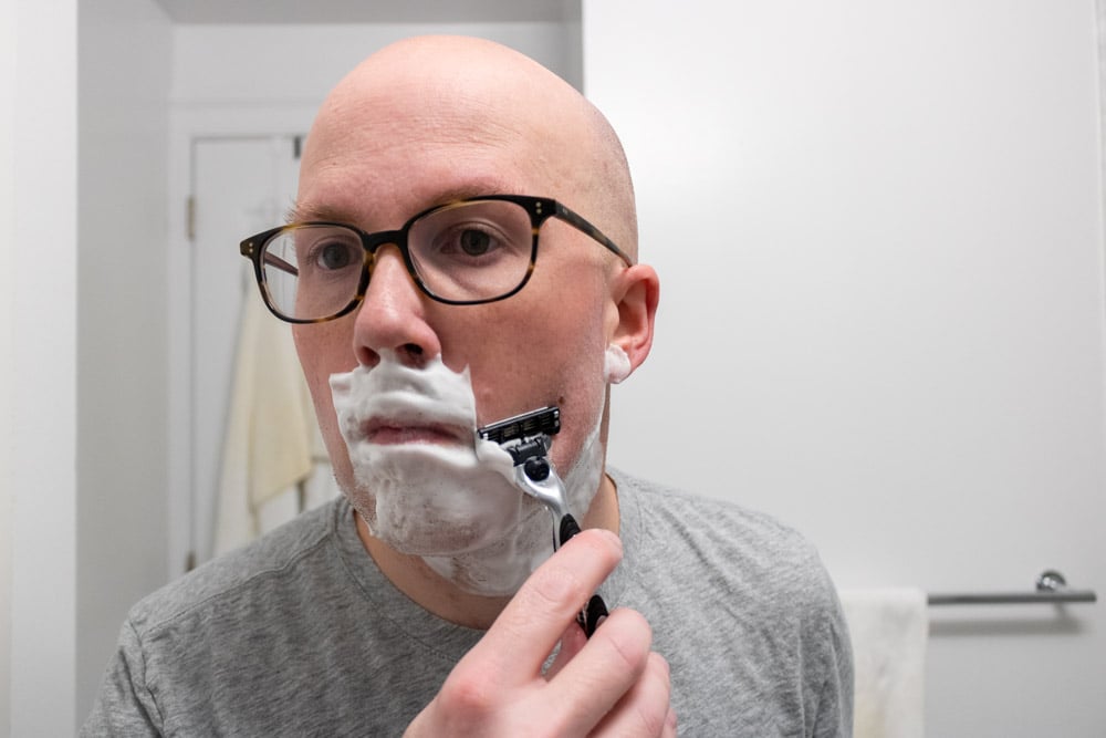 man shaving cheek with gillette mach3