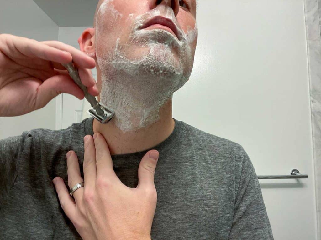 man shaving neck with safety razor 1