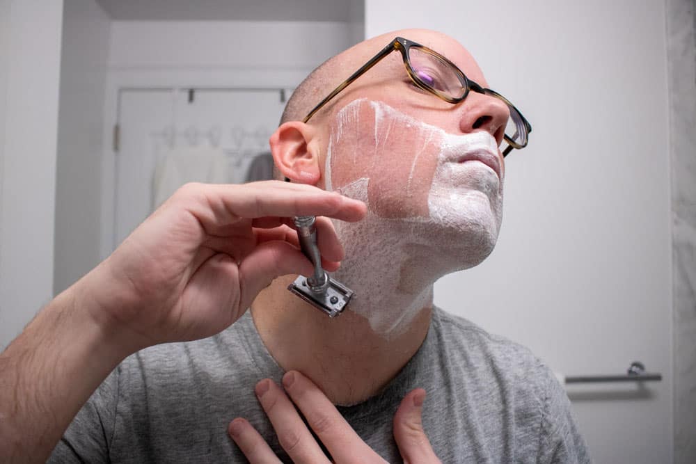 man shaving neck with safety razor 2