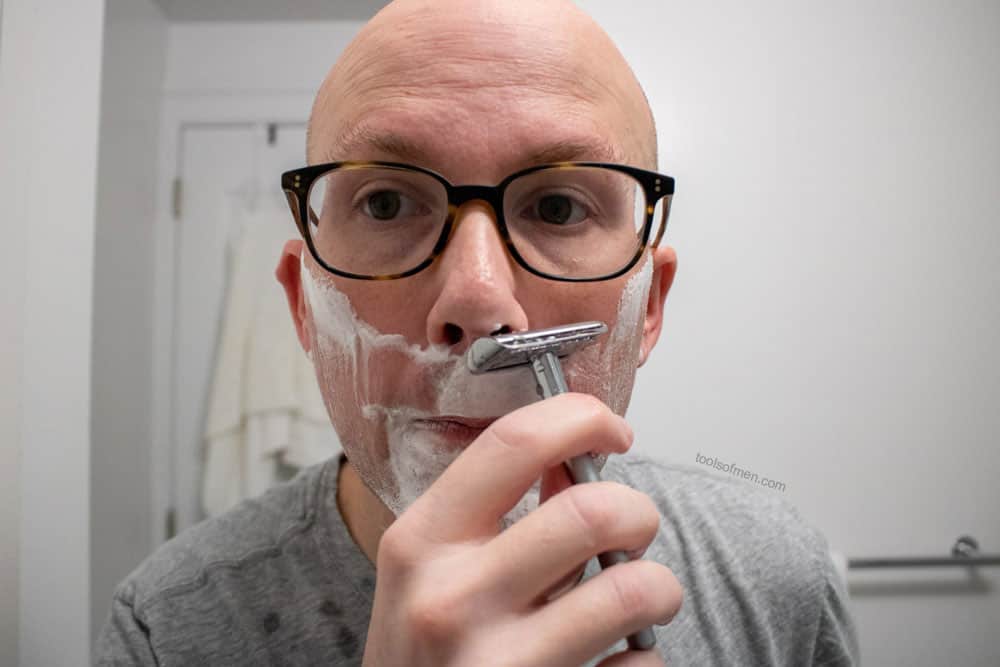 man shaving upper lip with bevel safety razor