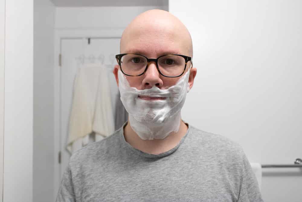 man smiling with shaving cream on face