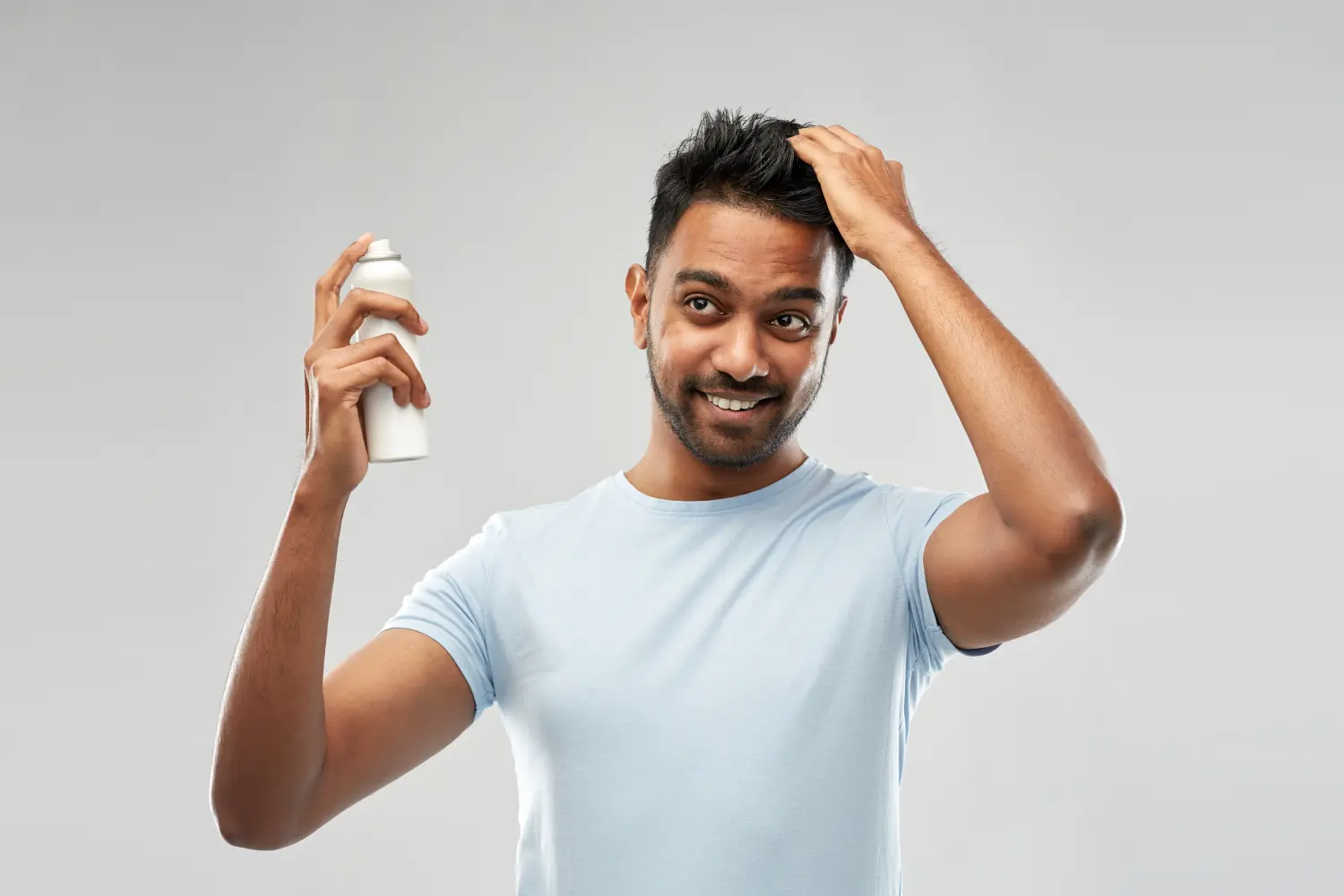 man spraying head with dry shampoo