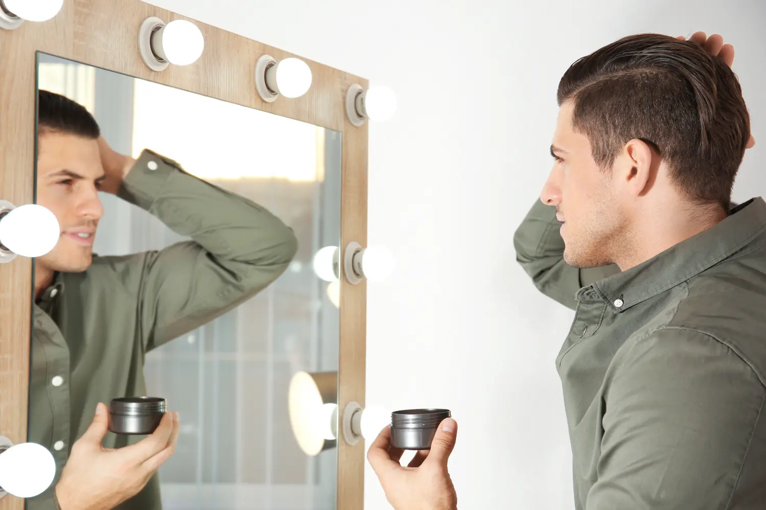 man styling hair in front of mirror