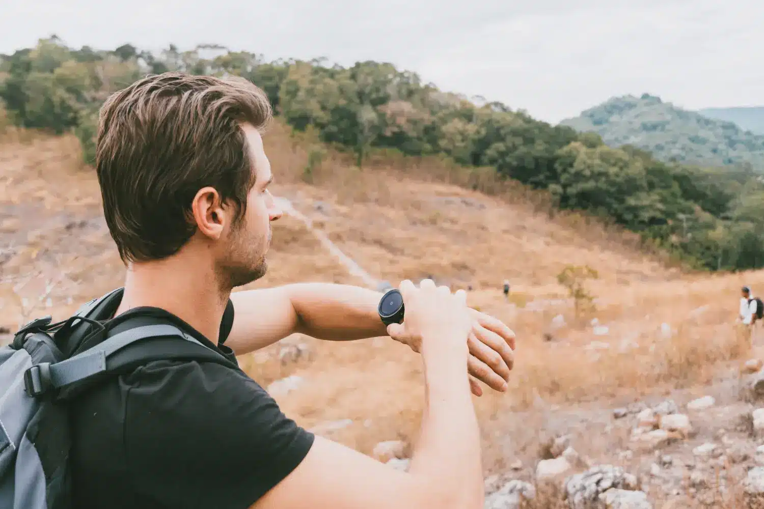man using compass watch while hiking