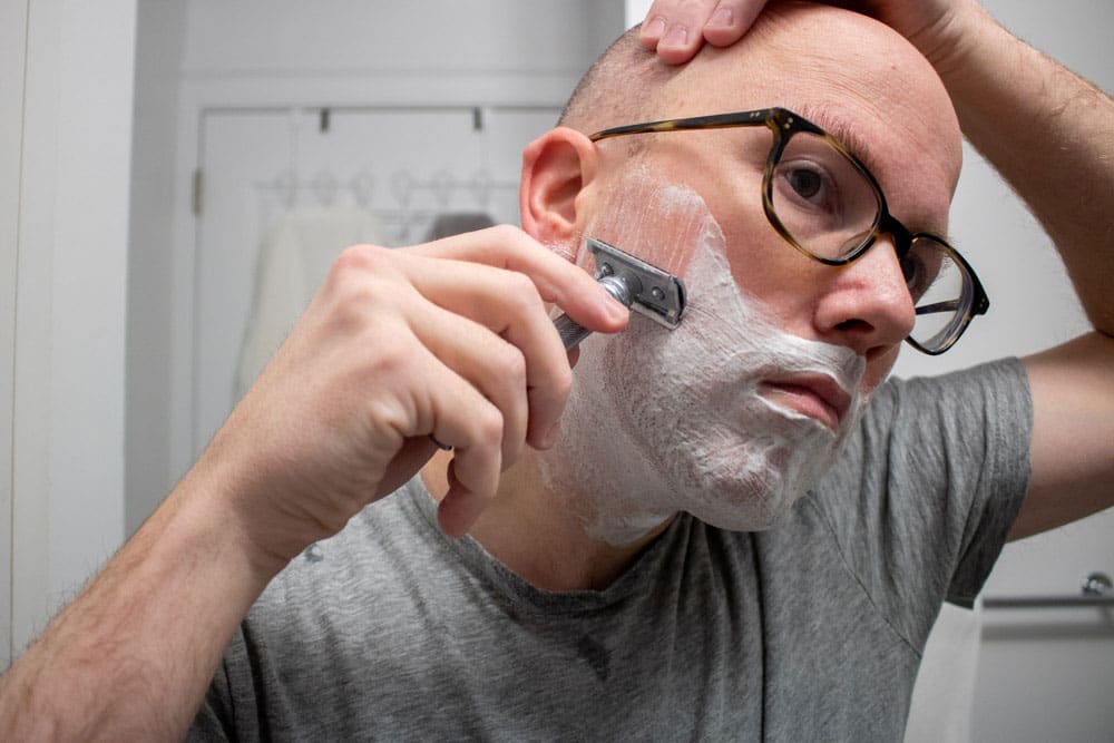 man using safety razor shaving cream is ghost town barber