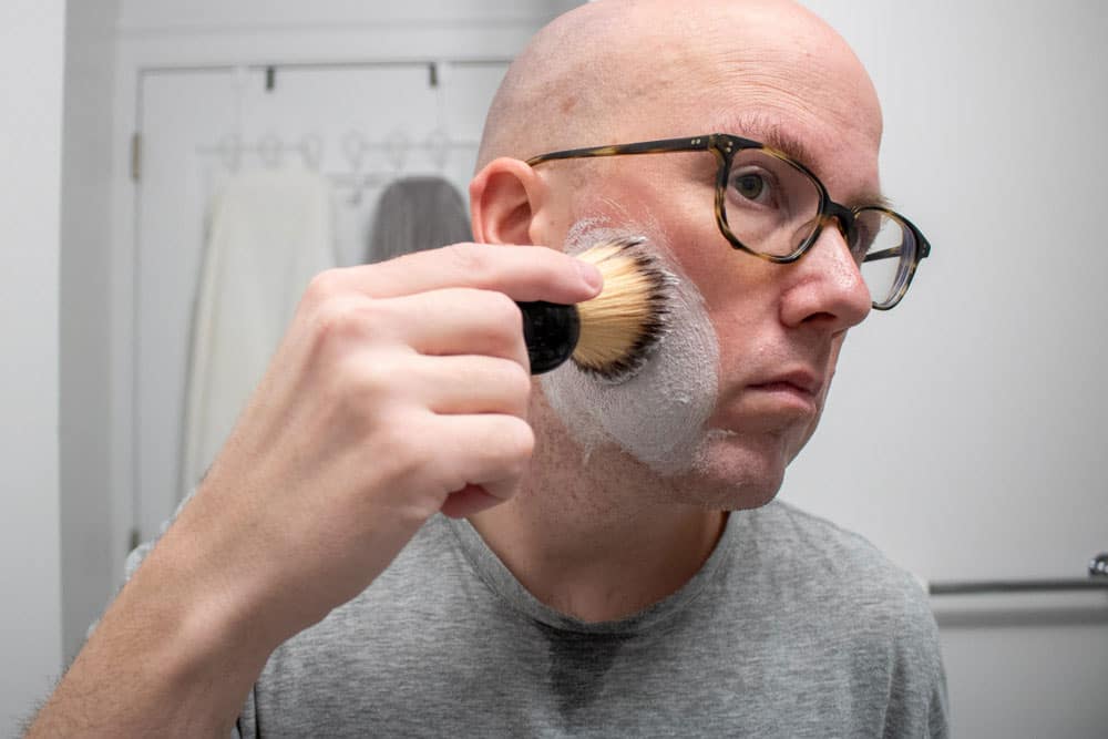 man using shaving brush to apply proraso shaving cream