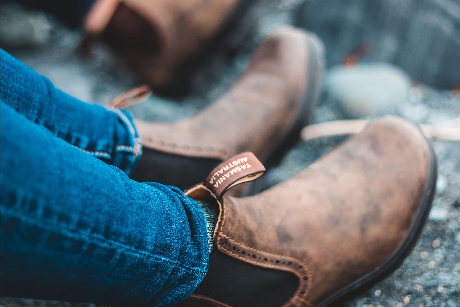 man wearing blue denim and brown chelsea boots