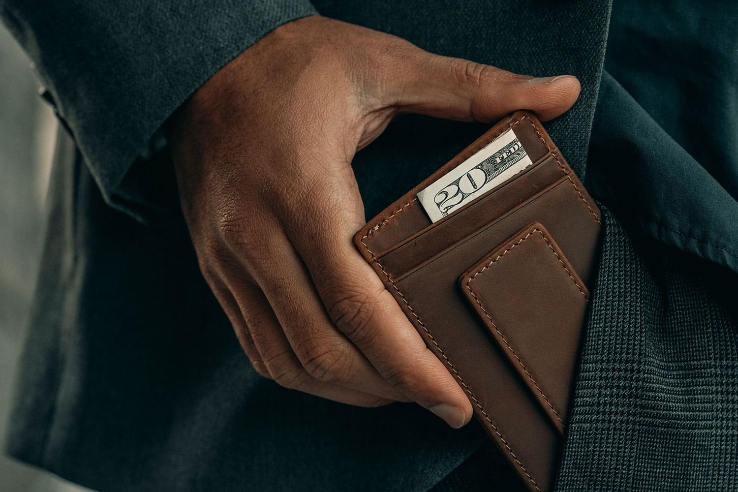 man wearing suit holding front pocket wallet
