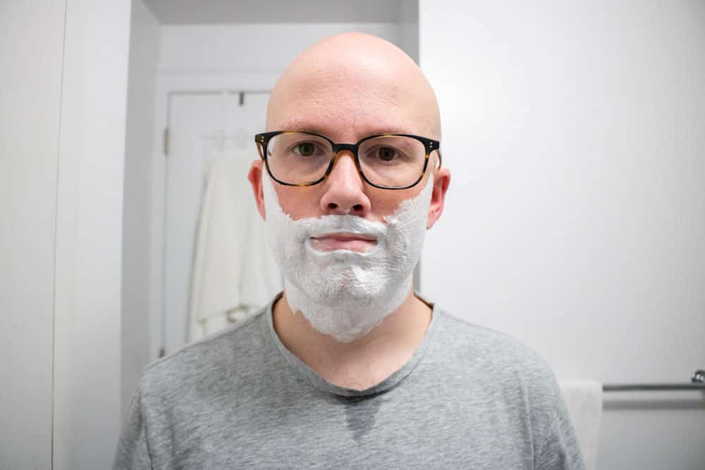 man with proraso shaving cream on face looking at camera