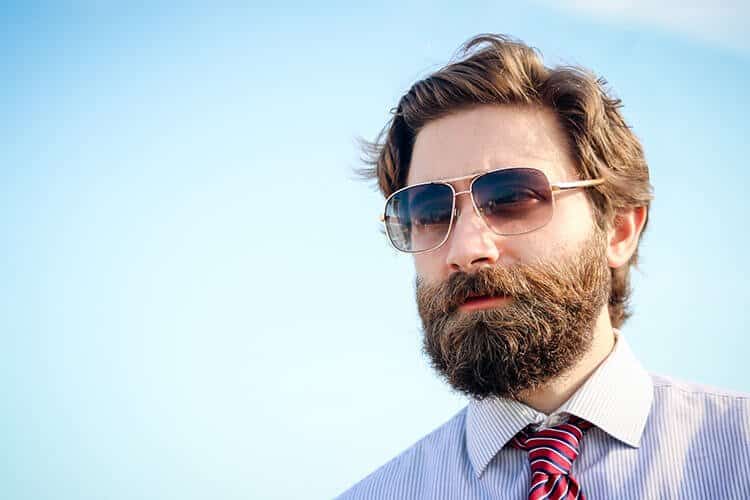man with sunglasses and thick beard on blue background