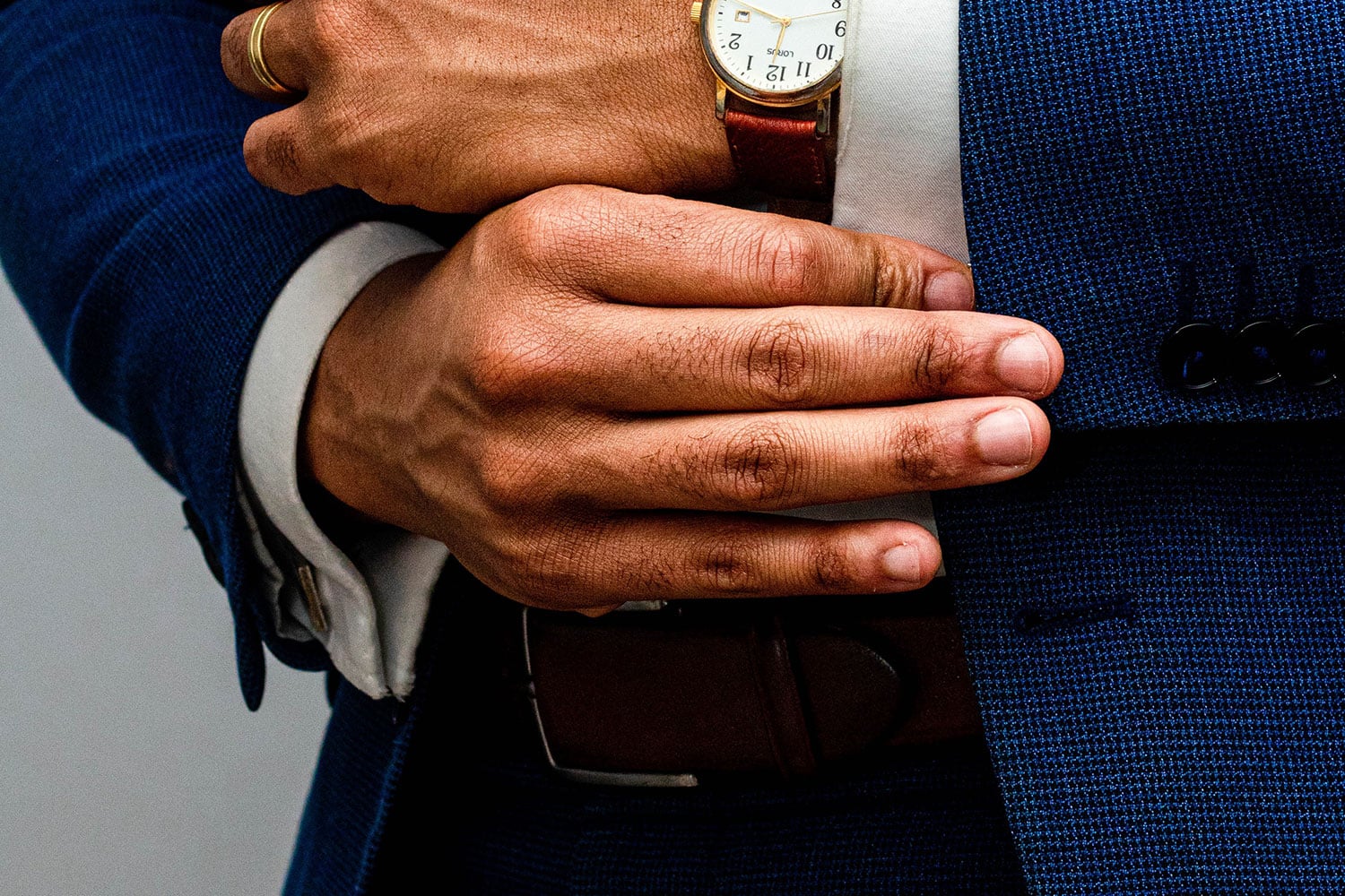 manicured man wearing blue suit and classic watch