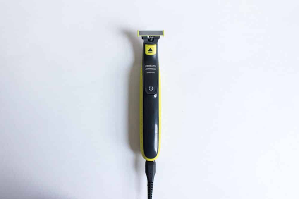 oneblade trimmer on white background while plugged in