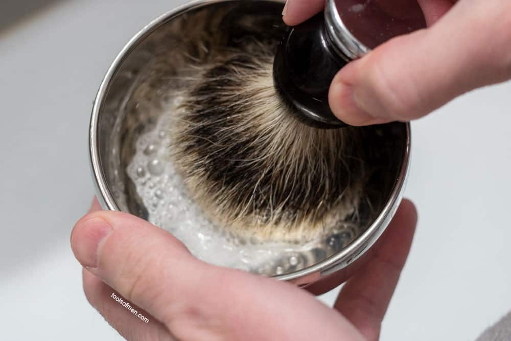 shaving brush lightly being pressed down in shaving bowl