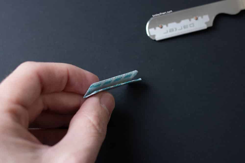 snapping a razor blade in the paper packaging