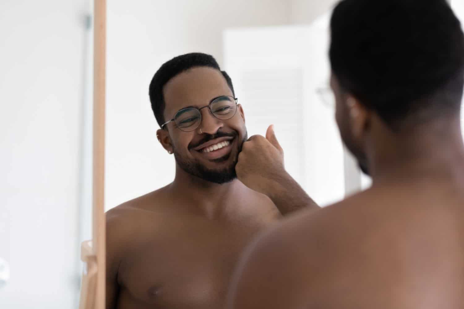 young man smiling at self in mirror