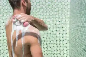 man washing shoulder with sponge