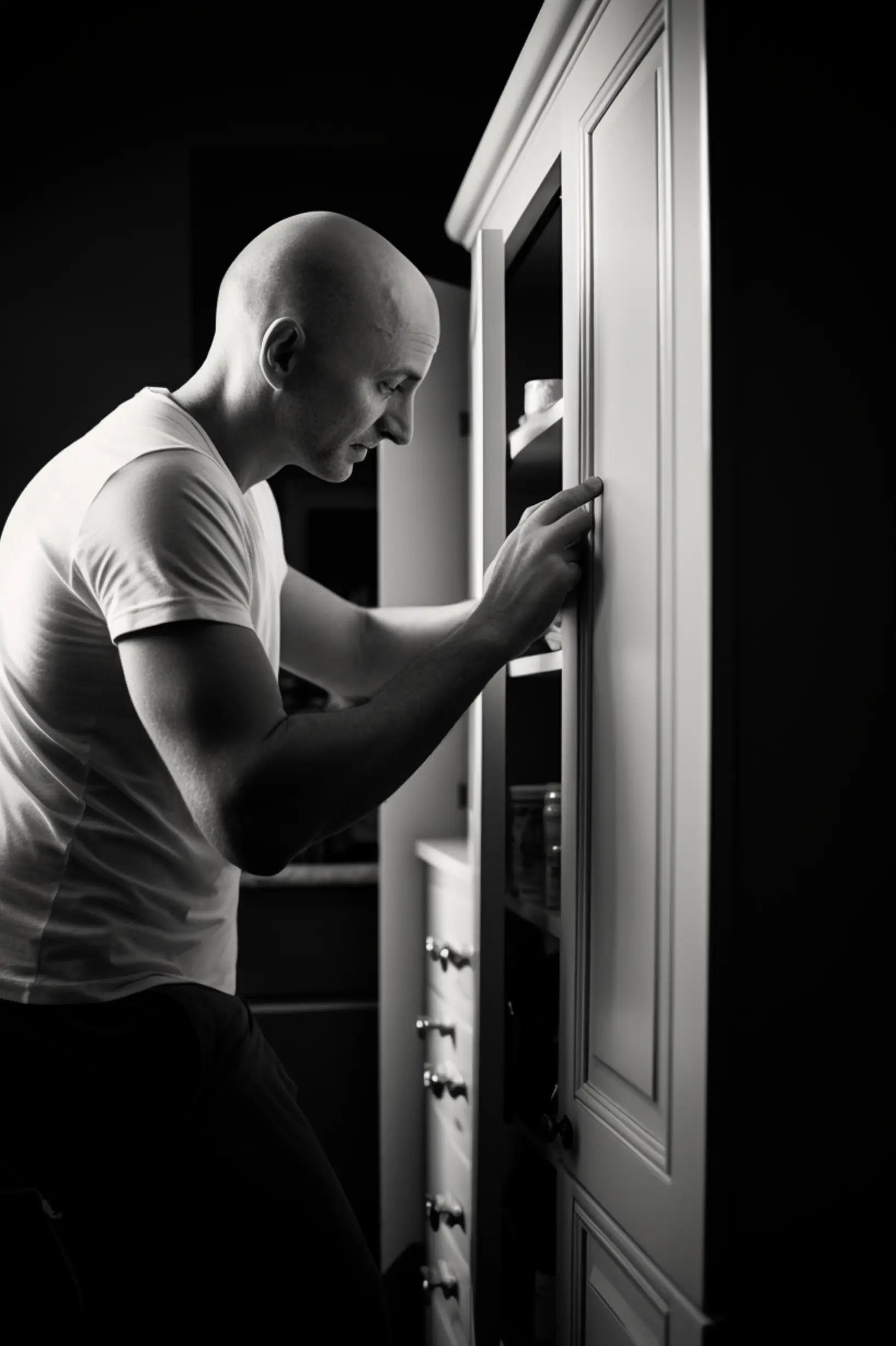 bald man getting items out of a medicine cabinet